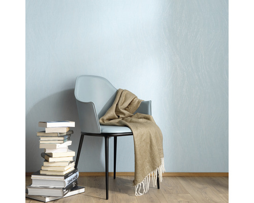 Szene mit Stuhl, Decke und Bücherstapel vor einer Wand