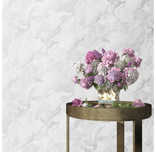 Wand mit Marmortapete und Tisch mit Blumen