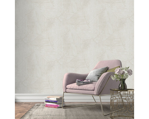 Szene mit einer Wand mit Vliestapete in Steinoptik, einem Sessel, einem Beistelltisch und Dekorationen für ein gemütliches Ambiente.