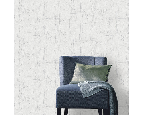 Tapete mit abstraktem Muster und Stuhl mit Kissen