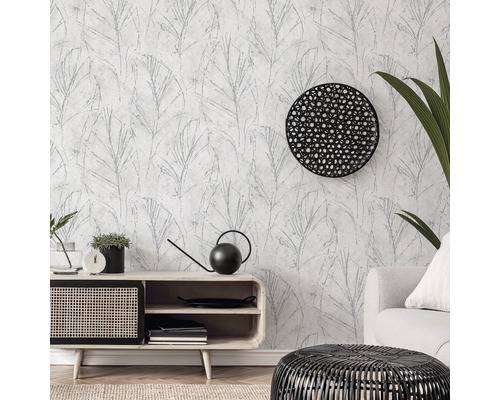 Wohnzimmer mit gemusterter Tapete, Sideboard, Sessel und Dekorationen.