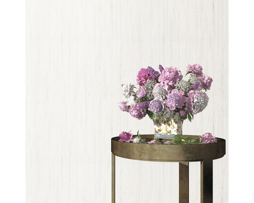 Blumenarrangement mit Pfingstrosen und Flieder auf einem Beistelltisch