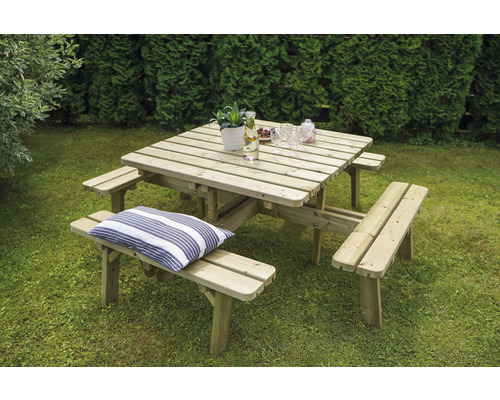 Quadratische Picknicktischgarnitur aus Holz mit Getränken und Dekoration im Garten.