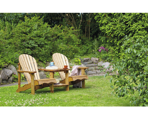 Zwei Adirondack Stühle aus Holz mit kleinem Tisch im Garten.