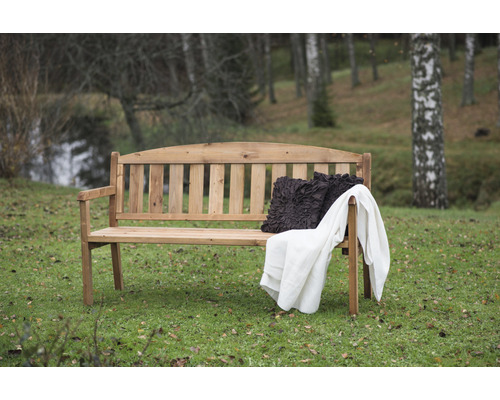 Holzgartenbank mit Kissen und Decke im Garten