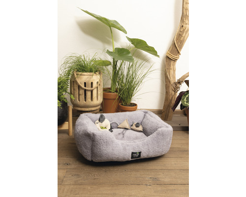 Graues Tierbett mit Spielzeugmäusen vor Pflanzen