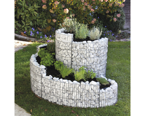 Gabionen-Kräuterspirale aus Steinen und Pflanzen im Garten