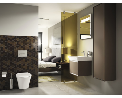 Modernes Badezimmer mit Toilette, Waschtisch und Spiegelschrank in einem Schlafzimmer.