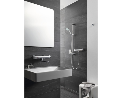 Modernes Badezimmer mit rechteckigem Spiegel, Aufsatzwaschbecken, Armaturen und Duschgarnitur.