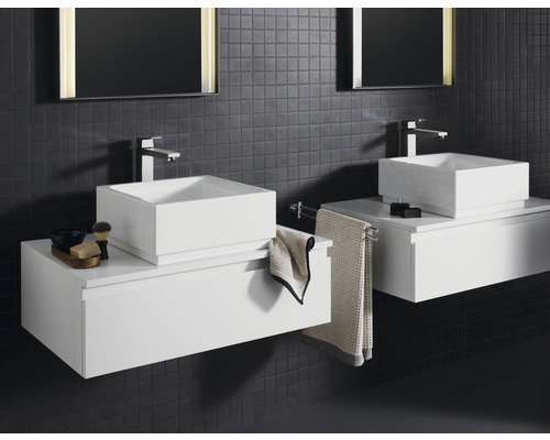 Badezimmer mit zwei Waschbecken, Waschtischen und Spiegeln an einer dunklen Wand