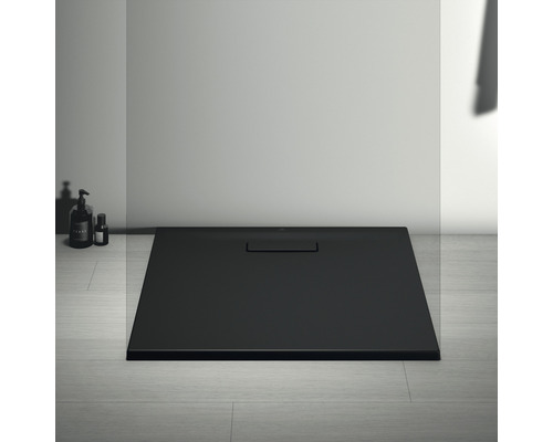 Schwarze Duschwanne mit Ablaufgarnitur im Badezimmer.