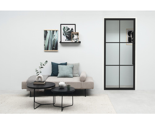 Wohnzimmer mit Tagesbett, Couchtischen, Wanddekoration und Flügeltür