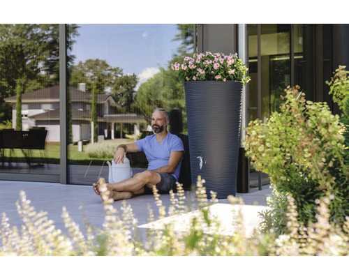 Szene mit Regentonne, Gießkanne und Mann im Garten