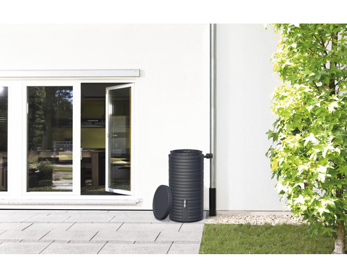 Regentonne aus Kunststoff neben Hauswand mit Fallrohr