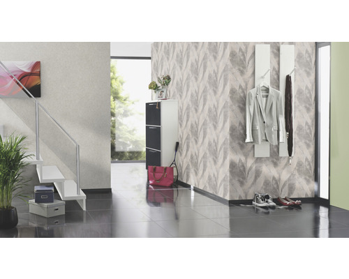 Heller Eingangsbereich mit Treppe, Schuhschrank und Garderobe vor einer gemusterten Tapete.