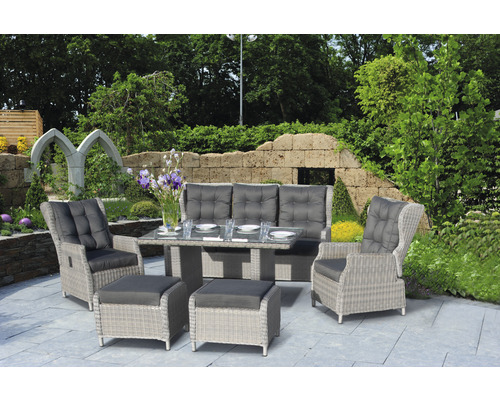 Gartenmöbelset mit Tisch, Sofa, Sesseln und Hockern auf einer Terrasse