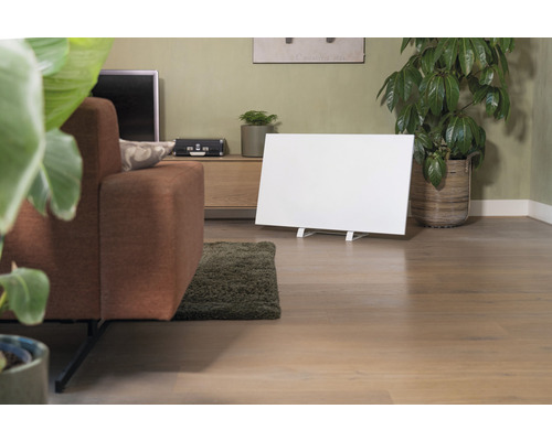 Wohnzimmer mit Sofa, Zimmerpflanzen, Kommode und einem weißen Infrarot Heizpaneel.