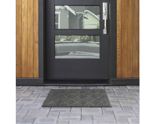 Fußmatte vor einer Haustür mit Fenster