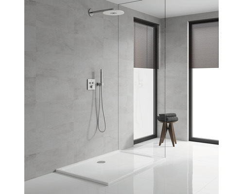 Duschbereich mit Duschwanne, Duschkopf, Armatur und Hocker mit Handtüchern in einem Badezimmer.