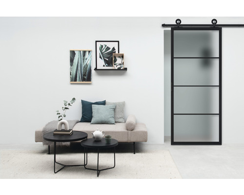 Wohnraum mit Schiebetür, Sofa, Couchtischen und Dekoration