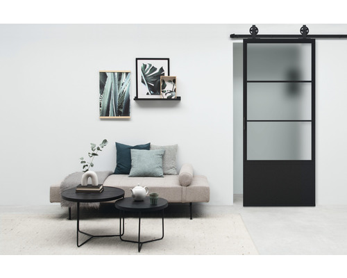 Wohnzimmer mit Schlafsofa, Couchtischen und Glasschiebetür