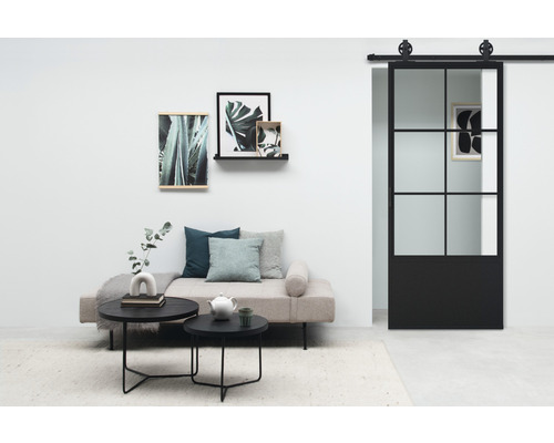 Wohnzimmer mit Sofa, Couchtischen, Wanddekoration und Schiebetür