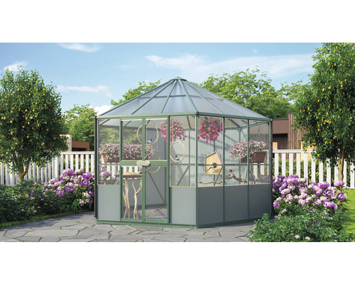 Gewächshaus mit Pflanzen und Vogelhaus im Garten