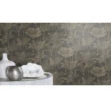 Nahaufnahme einer Wand mit Dschungeltapete mit Palmenmuster sowie einer Vase, einem Teelichthalter und einem weißen Kristall auf einem Tisch