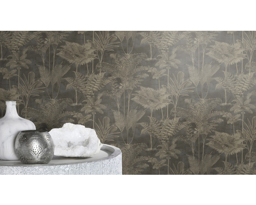 Nahaufnahme einer Wand mit Dschungeltapete mit Palmenmuster sowie einer Vase, einem Teelichthalter und einem weißen Kristall auf einem Tisch