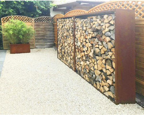 Gartenansicht mit Holzlagerregal und Kiesweg