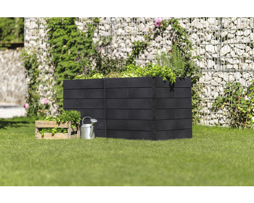 Hochbeet aus Holz mit Kräutern und Gemüsepflanzen im Garten