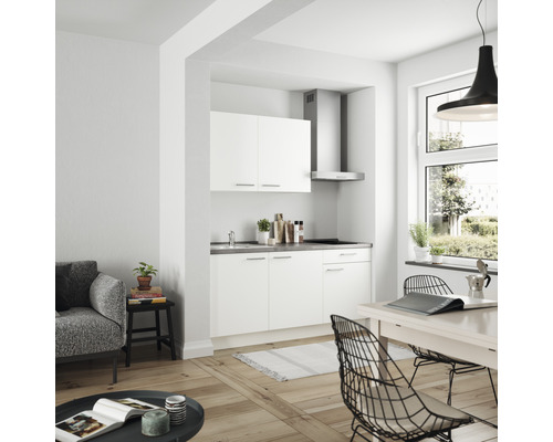 Helle Küchenzeile in einem modern eingerichteten Wohnraum mit Esstisch und Sitzgelegenheiten.