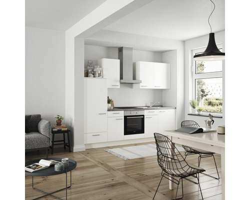 Helle Küche mit Küchenzeile, Hängeschränken, Dunstabzugshaube und Esstisch in einem modernen Wohnraum.