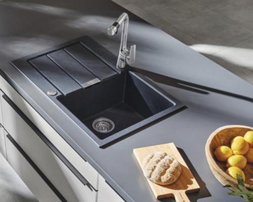 Küchenspüle mit Abtropffläche und Armatur auf einer Küchentheke