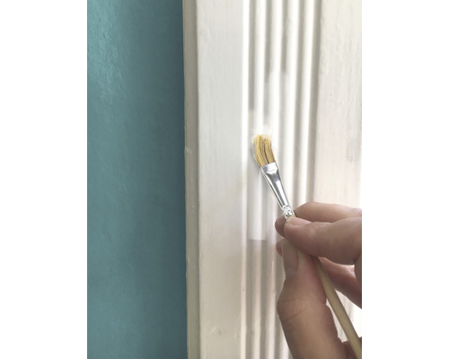 Anstrich einer weißen Zierleiste mit Pinsel