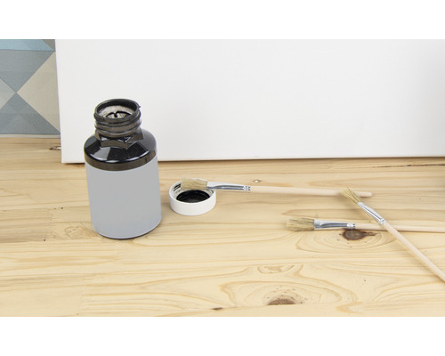 Farbeimer mit Pinsel auf Holzgrund