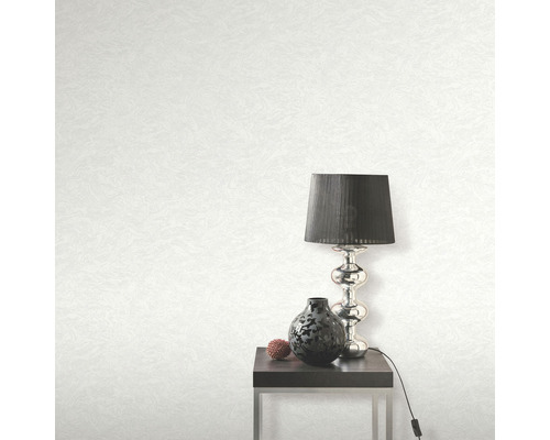 Helle Tapete mit Textur, Tischleuchte, Dekoration und Beistelltisch im Raum.