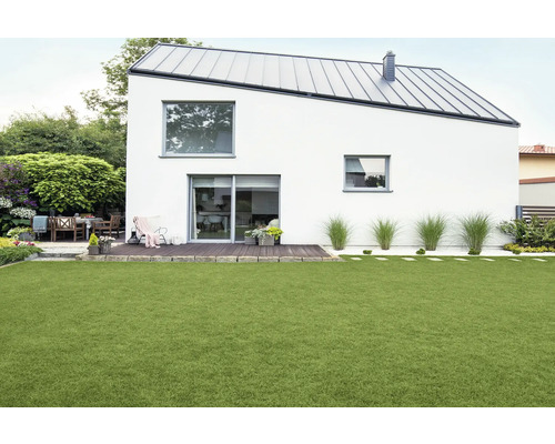 Modernes Haus mit Garten, Terrasse und Rasenfläche.