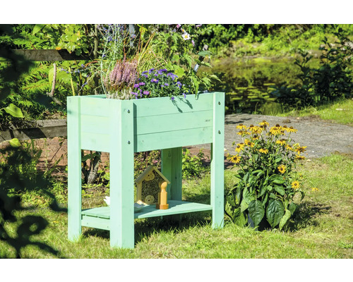 Hochbeet aus Holz mit Pflanzen und Insektenhotel im Garten
