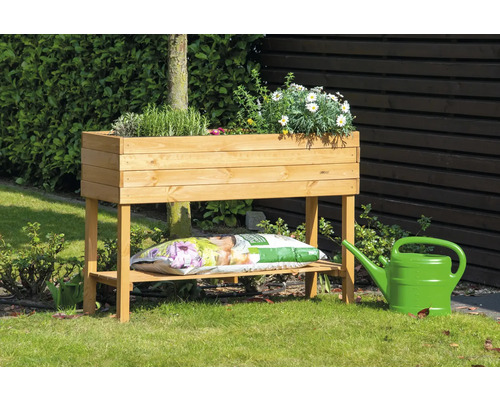 Holz Pflanztisch mit Pflanzen, Blumenerde und Gießkanne im Garten