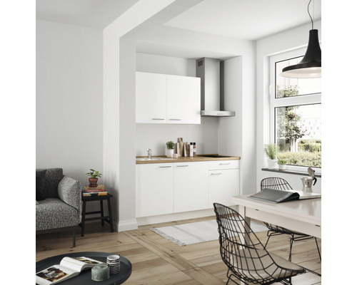 Helles Wohnzimmer mit Küchenzeile, Esstisch und Sofa.