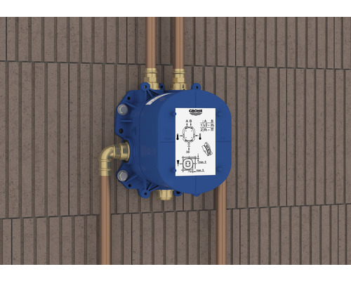 Blauer Grohe Unterputzkörper mit Rohren an einer Wand