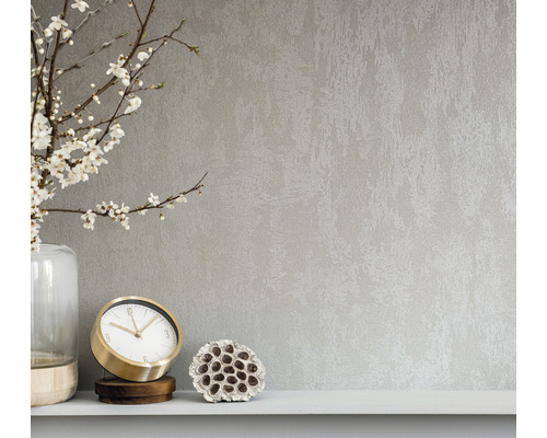 Nahaufnahme einer Wandtapete mit abstrakter Textur, kombiniert mit einer Vase, einer Uhr und einer Lotusblume auf einem Regal