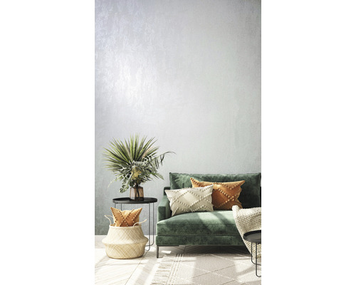 Wohnzimmer mit grüner Couch, Kissen, Beistelltischen und Dekorationen für eine helle und einladende Atmosphäre.