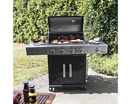 Gasgrill mit Grillgut, Seitenablagen und Unterschrank im Garten