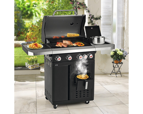 Schwarzer Grillwagen mit Grillgut, Beilage und Fritteuse im Garten