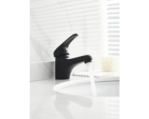 Schwarzer Wasserhahn mit fließendem Wasser auf einem Waschbecken