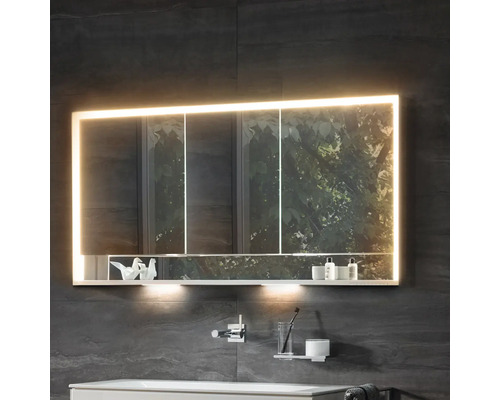 Beleuchteter Spiegelschrank im Badezimmer mit Ablagefläche für Badutensilien.