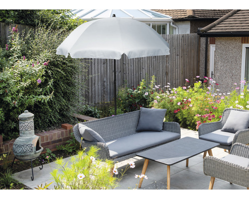 Gartenmöbel-Set mit Sonnenschirm, Sofa, Sesseln und Tisch auf einer Terrasse.
