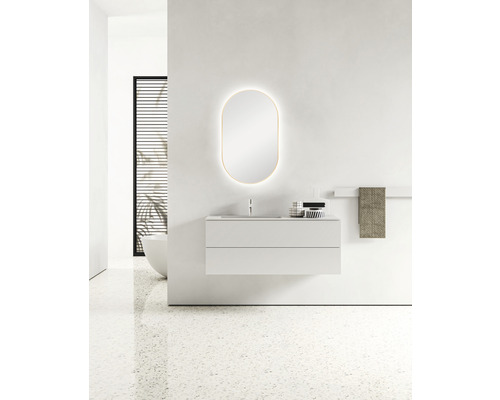 Modernes Badezimmer mit Waschtisch, beleuchtetem Spiegel und Handtuchhalter.